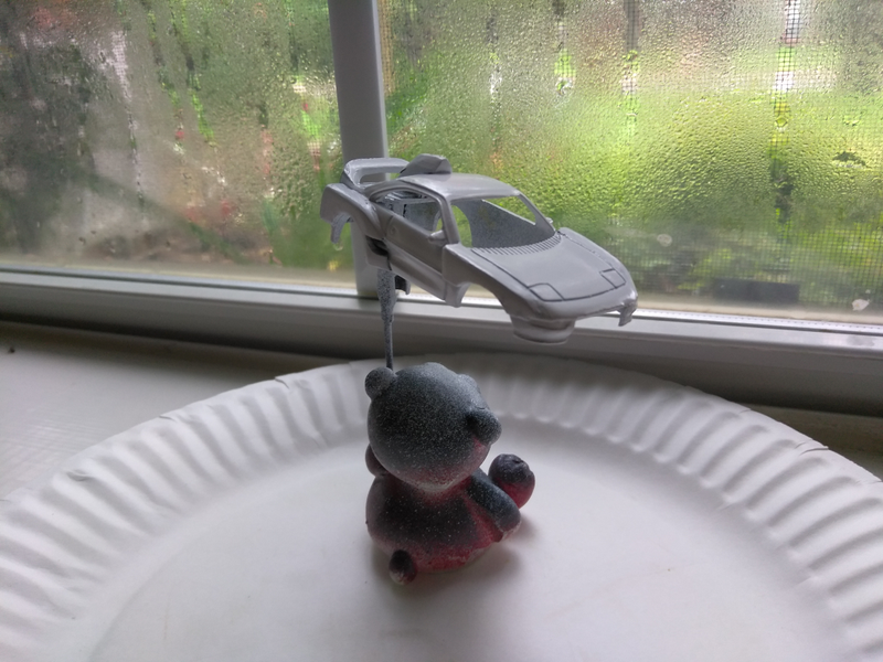 Mr. Bear watches the rain while he waits for the paint to dry.